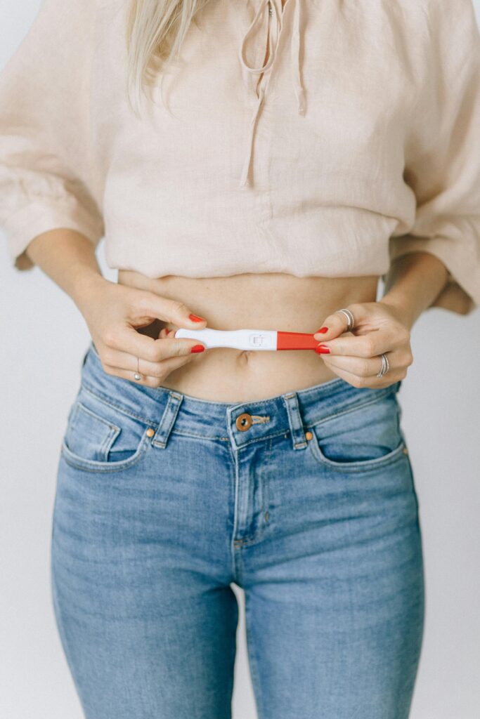 Close-up of a woman holding a positive pregnancy test, depicting a moment of happiness.