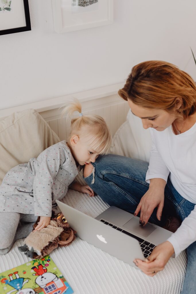 Mother and daughter enjoying technology time together on a cozy sofa.